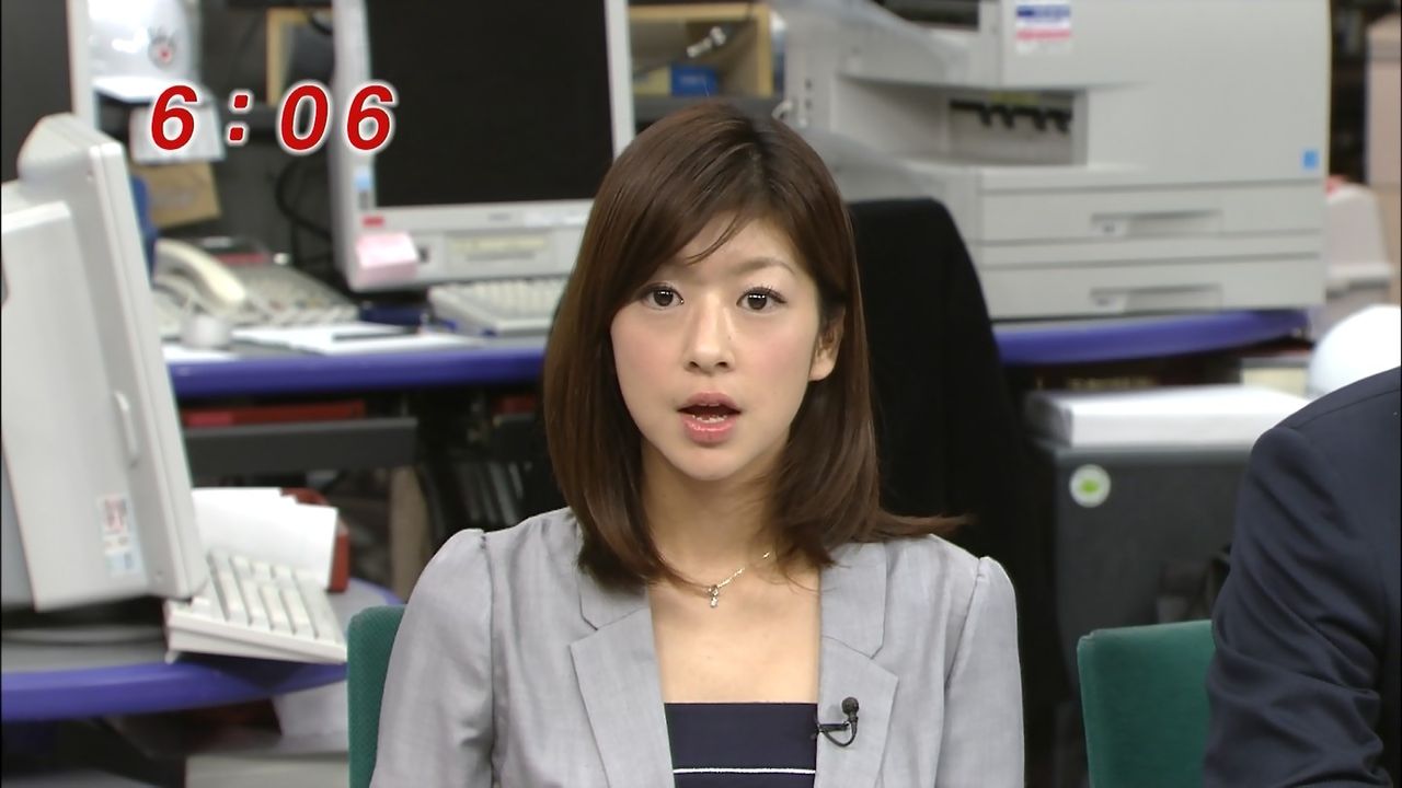 グレーのスーツを着て真面目な表情でニュースを読むアナウンサー、生野陽子