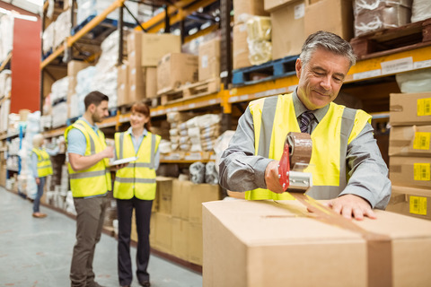 bigstock-Warehouse-worker-sealing-cardb-81087872
