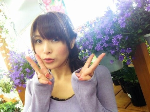 紫のお花を前に微笑む新田恵海