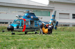 長野県警ヘリコプターで搬送・収容された新井裕己監督=28日午前8時54分、長野県大町市観音橋ヘリポートで