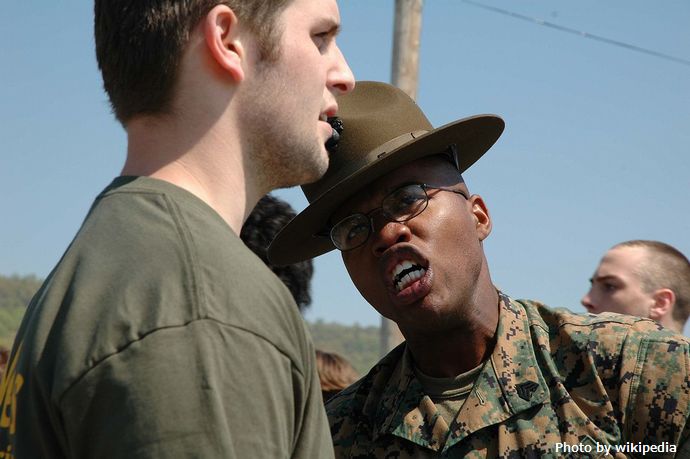 1280px-Marine_Corps_drill_instructor_yells_at_recruit