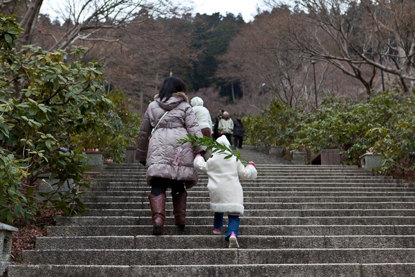 雪の舞う中階段を上がる娘