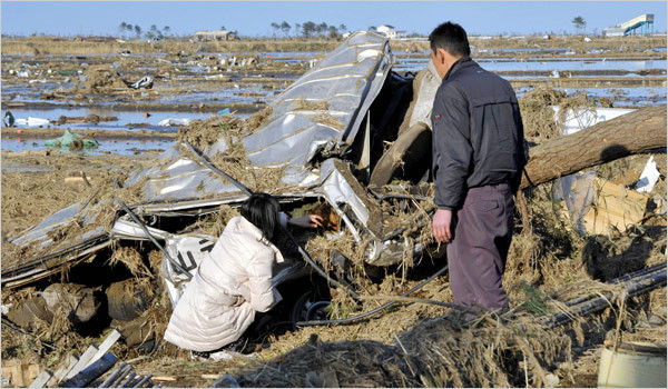 スクールバスの残骸に閉じ込められた娘の死体を撫でる両親(宮城県山元町)
