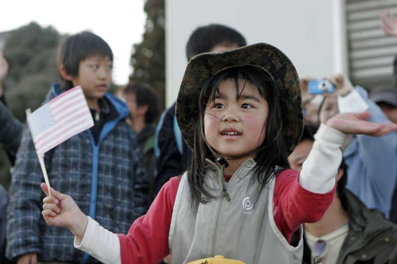 帰投する海兵隊員を見送る少女