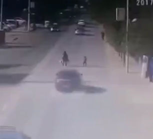 親子が道を渡ろうとするが、猛スピードの車が子供だけ撥ね飛ばしてしまう