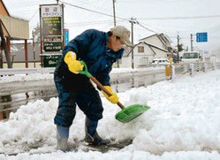 道に積もった雪をかき出す村民=白馬村の国道148号沿いで