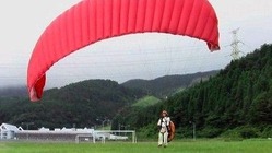 パラグライダーの体験会に先駆けて行われた試験飛行=7月、佐賀市富士町の天山スキー場(佐賀市観光協会提供)