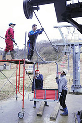 スキーシーズンを前に、リフトの座席を取り付ける職員ら=七尾市多根町で
