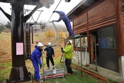 雨の中、リフトを取り付ける職員=恩原高原スキー場