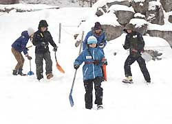 雪崩で人が埋まった事故を想定し、捜索訓練をする参加者