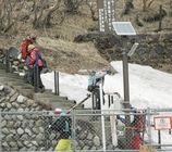 スキーの板やスノボードを担ぎ、通行禁止区域の登山道を降りてくる愛好者