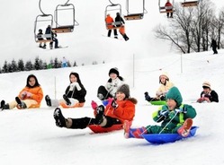 新雪のゲレンデでそり遊びを楽しむ家族連れら14日、福井県勝山市のスキージャム勝山