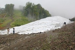 五輪本番での雪不足に備えて保存されている雪の山。断熱シートで覆われている=ロシア・ソチで2013年8月7日、田中洋之撮影
