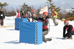 雪玉を投げる参加者=北杜市大泉町西井出のサンメドウズ清里スキー場で