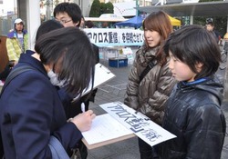 屋内スノーボード場「アクロス重信」の存続を求め署名活動をする人たち=22日、松山市