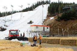 山肌が見えるモーグル、エアリアル会場(後方)。コース上に山頂から雪上車で雪が集められ、かさ上げのための干し草が準備される=飯塚晋一撮影