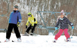 たっぷりと雪が残るゲレンデで滑りを楽しむ子どもたち=23日午後1時20分ごろ、スプリングバレー泉高原スキー場