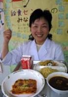 考案したイタリアンの五輪応援給食を手に笑顔を見せる小野栄養士