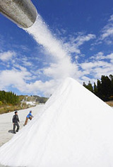秋めく景色の中、ゲレンデに勢いよく噴射され、雪山をつくる人工雪=22日午前11時50分、郡上市白鳥町石徹白、ウイングヒルズ白鳥リゾート