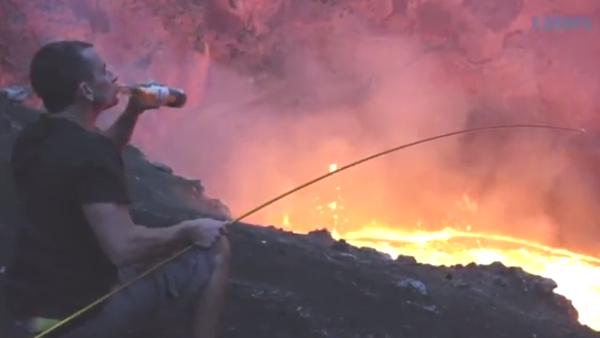溶岩火口で釣りをする男性