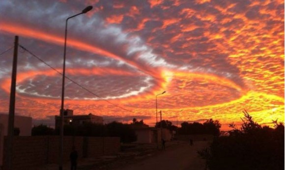 幻想的以上に超魔界的。チェニジアの上空を覆う夕焼に染まった3つの重なり合う輪、消散航跡。