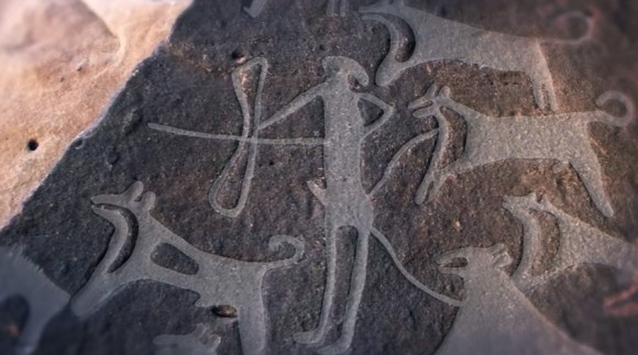 狩りをする人とリードにつながれた犬の姿。人類が描いた最古の犬の絵と思われる8000年以上前の岩面彫刻（サウジアラビア）