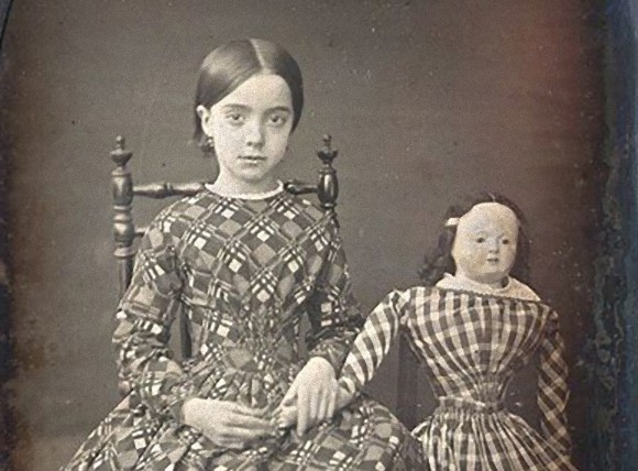 何かが怖いなんだろう？古い時代の少女とお人形のツーショット写真