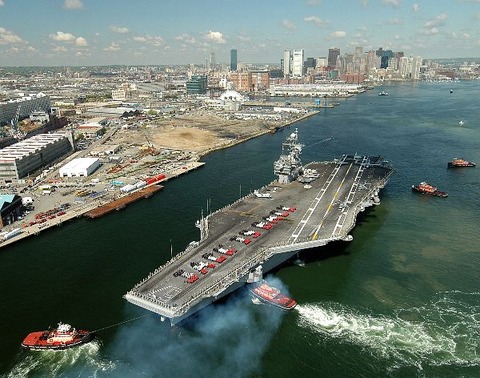 Description: The conventionally powered aircraft carrier USS John F. Kennedy (CV 67) makes her way into historic Boston Harbor as crew members are in formation on the flight deck to spell-out JACK IS BACK. usnavy11