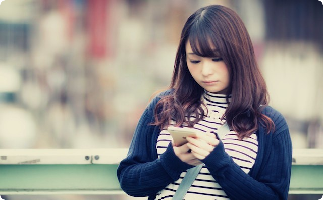 スマホをいじる女性