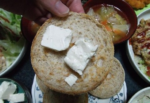 クリームチーズをイングリッシュマフィンパンに乗せて食べる写真