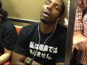 地下鉄乗車の黒人のTシャツが私は佐藤ではありませんって意味不明の爆笑画像