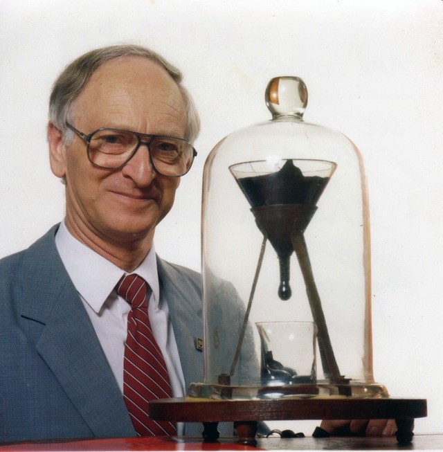 1024px-Pitch_drop_experiment_with_John_Mainstone