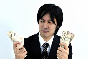 お金を握り締める男性