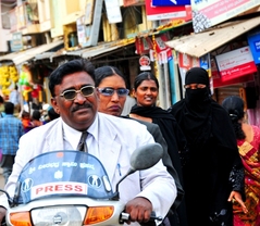 バンガロールの街中でバイクに乗る記者二人