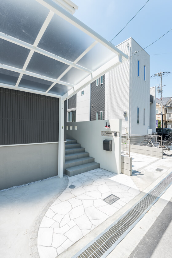 アプローチ通路は、ユニソンの乱形石「クレモナプレート」を敷き詰め、縁取りは「ピンコロ石(白御影)」でボーダー状に仕上げました