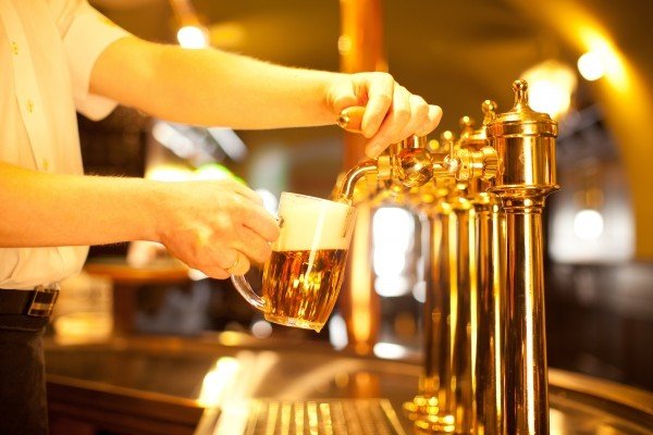 waiter-pouring-beer-at-counter-in-pub