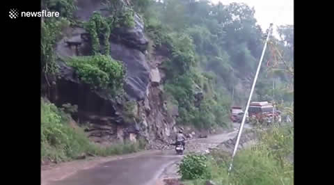 Close call motorcyclist avoids landslide by inches