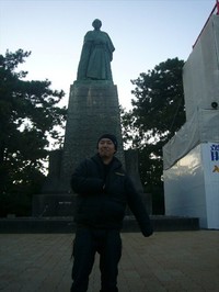 坂本龍一像の前で