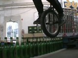 一列に並べられた144本のビール瓶を一輪車で渡る
