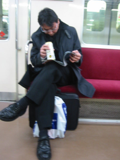 man drinking beer on train