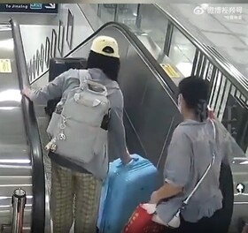 エスカレーターから荷物を落とす中国人女性 