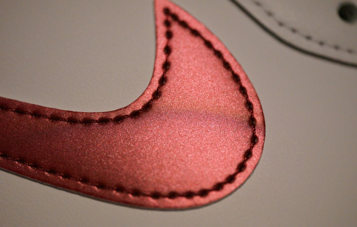 光沢のあるメタリックバーガンディのスウッシュの表面は非常に滑らか。