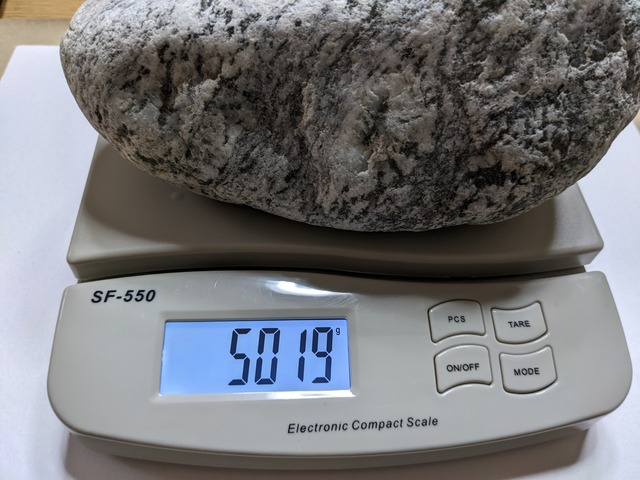 スケールで石の重量を測る
