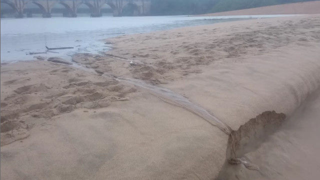 決壊した砂のダムが、みるみるうちに崩れていく風景