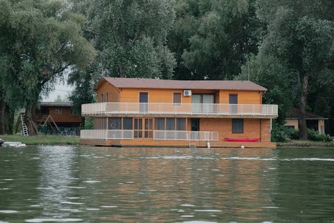 free-photo-of-a-house-floating-on-the-water-with-a-boat-on-it