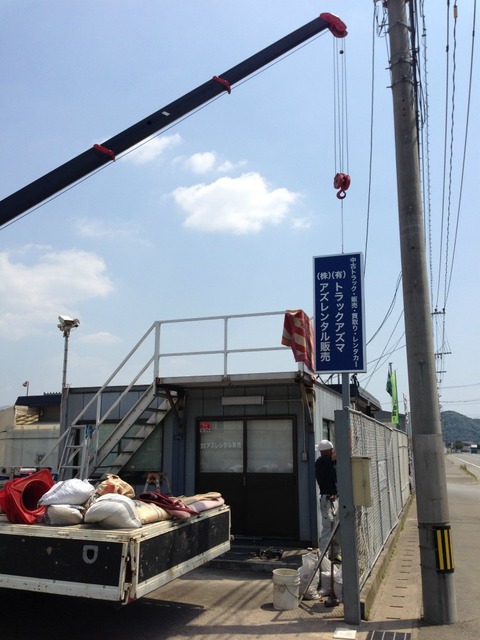クレーンで看板を設置中