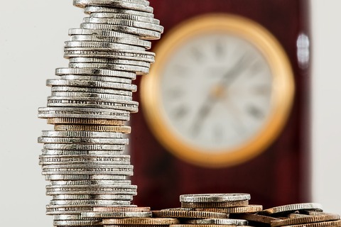 時計と積み重なったコイン(硬貨)