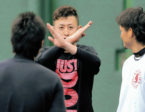 練習中、カメラに向かいバツを出す今成