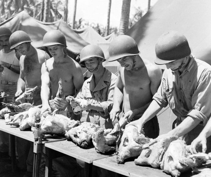 1942年12月25日、太平洋戦線の激戦地ガダルカナル島でクリスマスディナーの準備で七面鳥の下処理をする米海兵隊員！