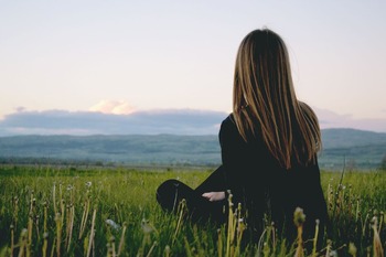 woman-wearing-black-long-sleeved-shirt-sitting-on-green-691919